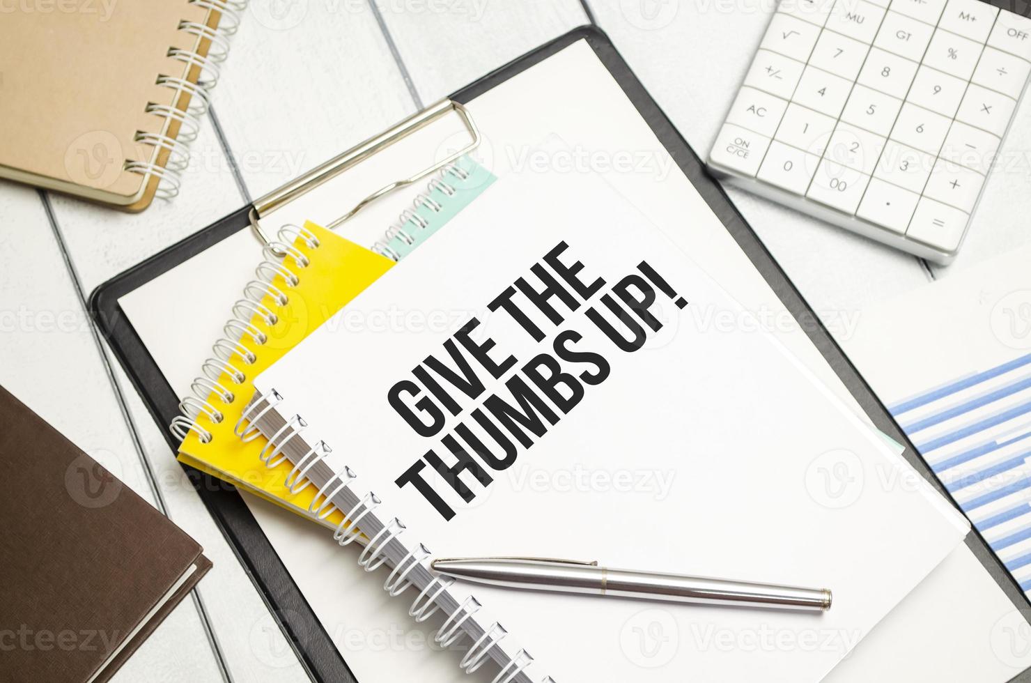give the thumbs up . Conceptual background with chart ,papers and pen photo