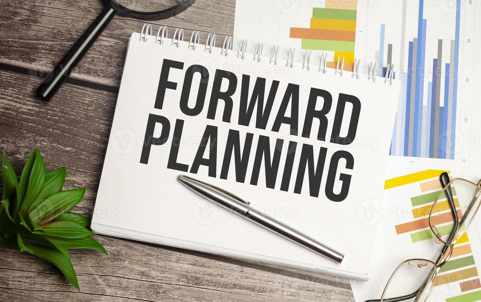 white notebook with forward planning words and charts photo