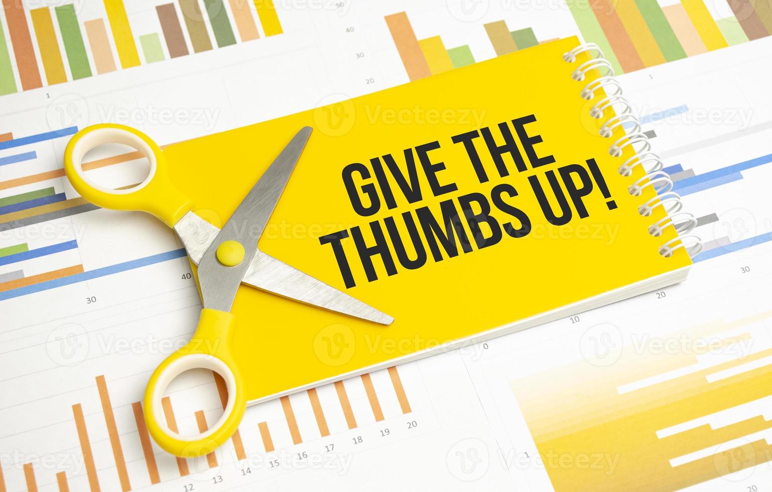 give the thumbs up. Text on yellow notebook and charts photo