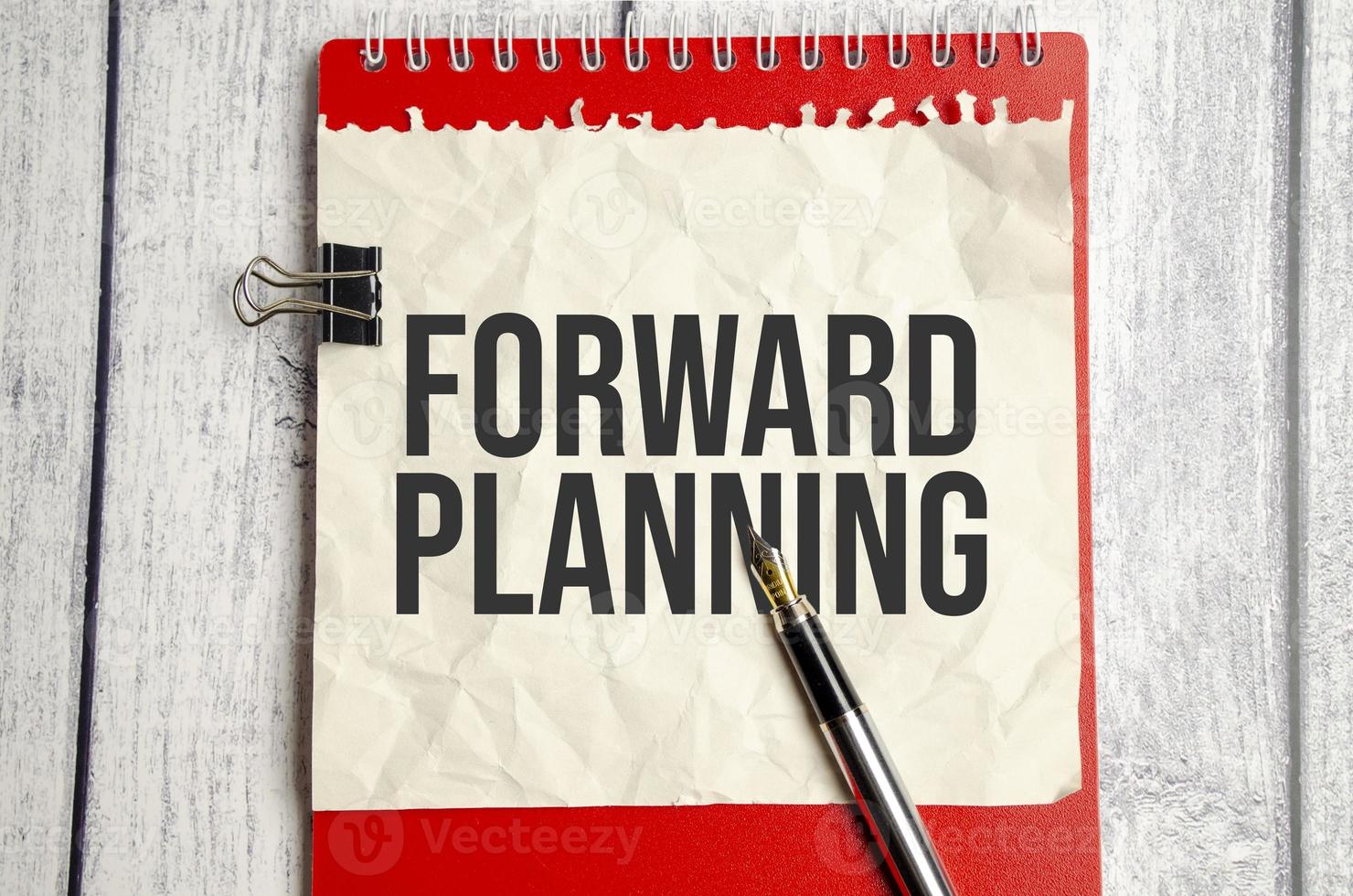 red notebook, forward planning words and white background photo