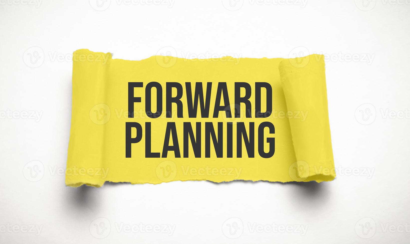 yellow torn paper with forward planning words photo