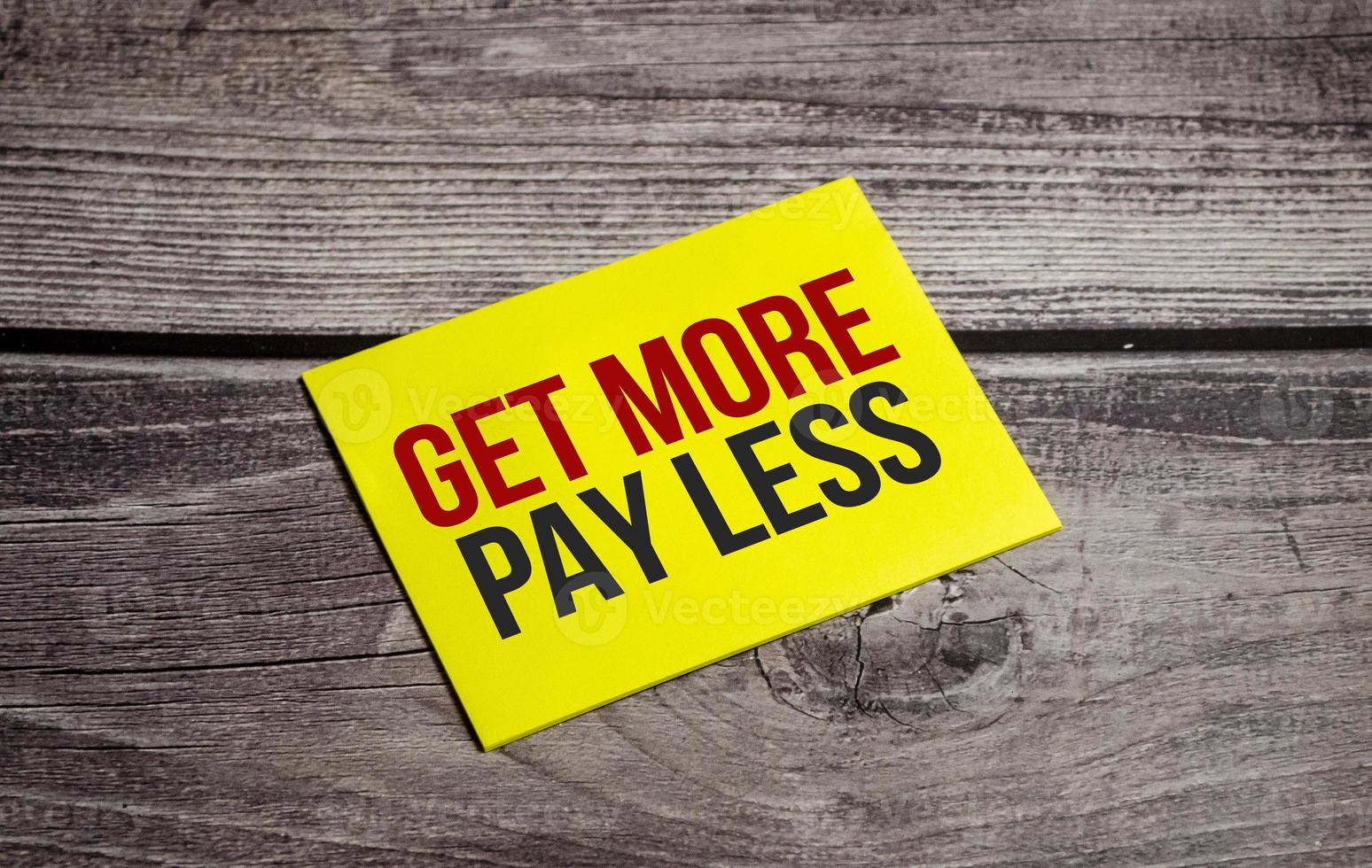 get more pay less Text on business paper on office table photo