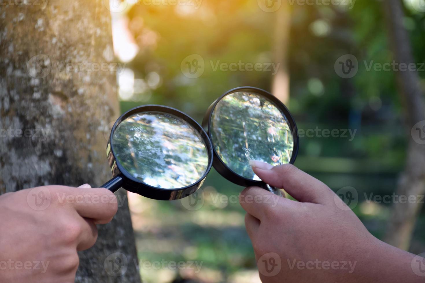Two small black magnifying glasses holding in hands and were used during the summer camp to study microorganisms in plants and plants diseases. photo