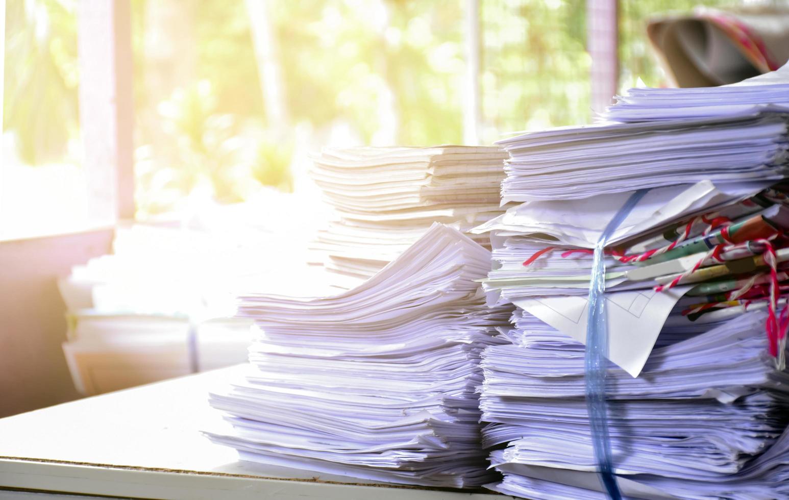 Used paper of various sizes is bundled together to sell or make recycled paper on the front porch of an office, soft focus, sunlight edited, environmental frineds concept. photo