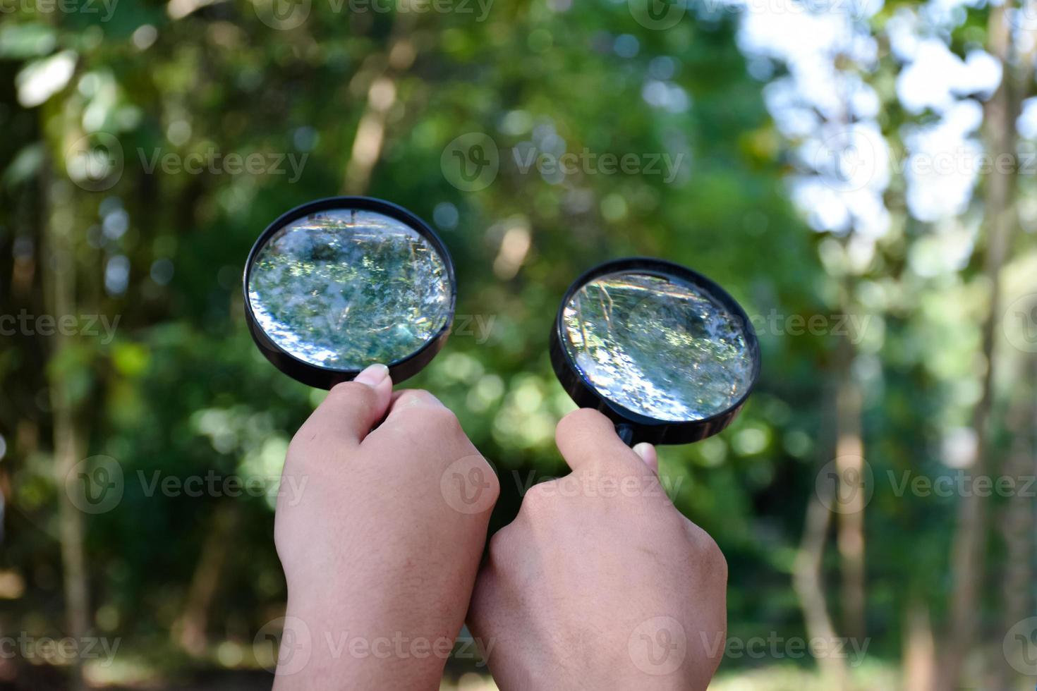 Two small black magnifying glasses holding in hands and were used during the summer camp to study microorganisms in plants and plants diseases. photo