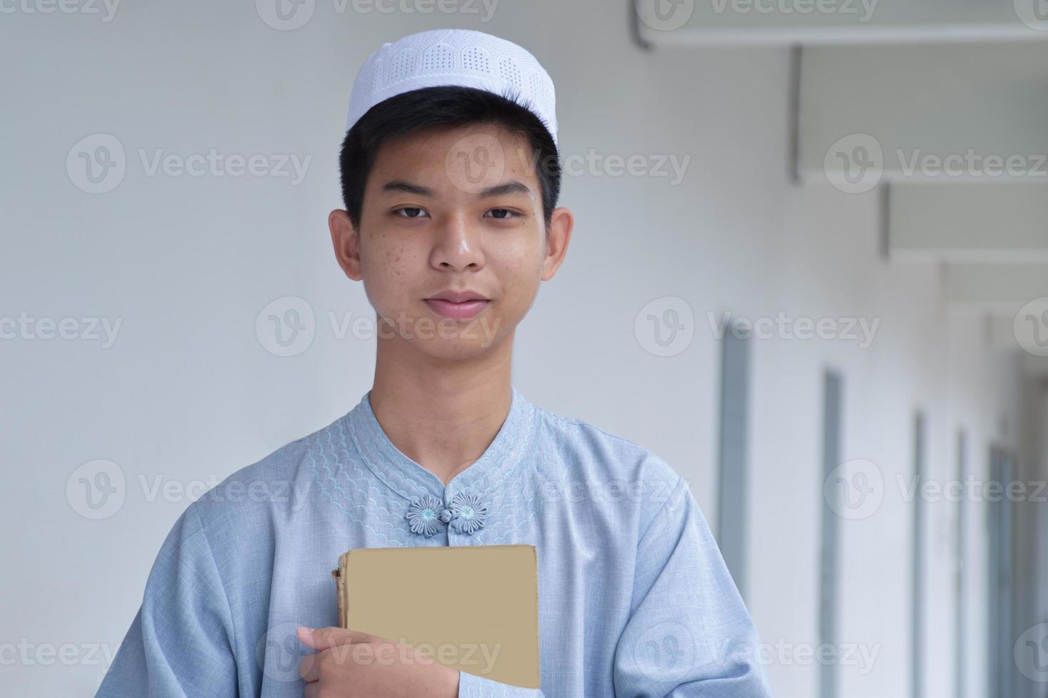 Portrait young southeast asian islamic or muslim boy in white shirt and hat, isolated on white, soft and selective focus. photo