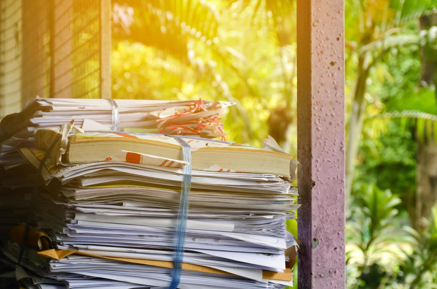 Used paper of various sizes is bundled together to sell or make recycled paper on the front porch of an office, soft focus, sunlight edited, environmental frineds concept. photo