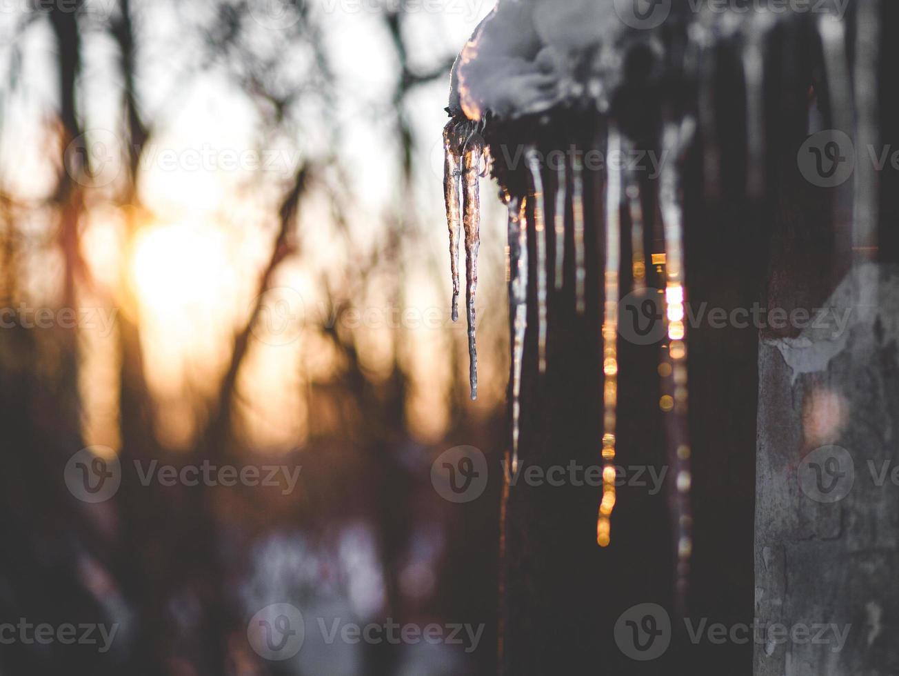 Winter, icicles hanging from the roof, sunset photo