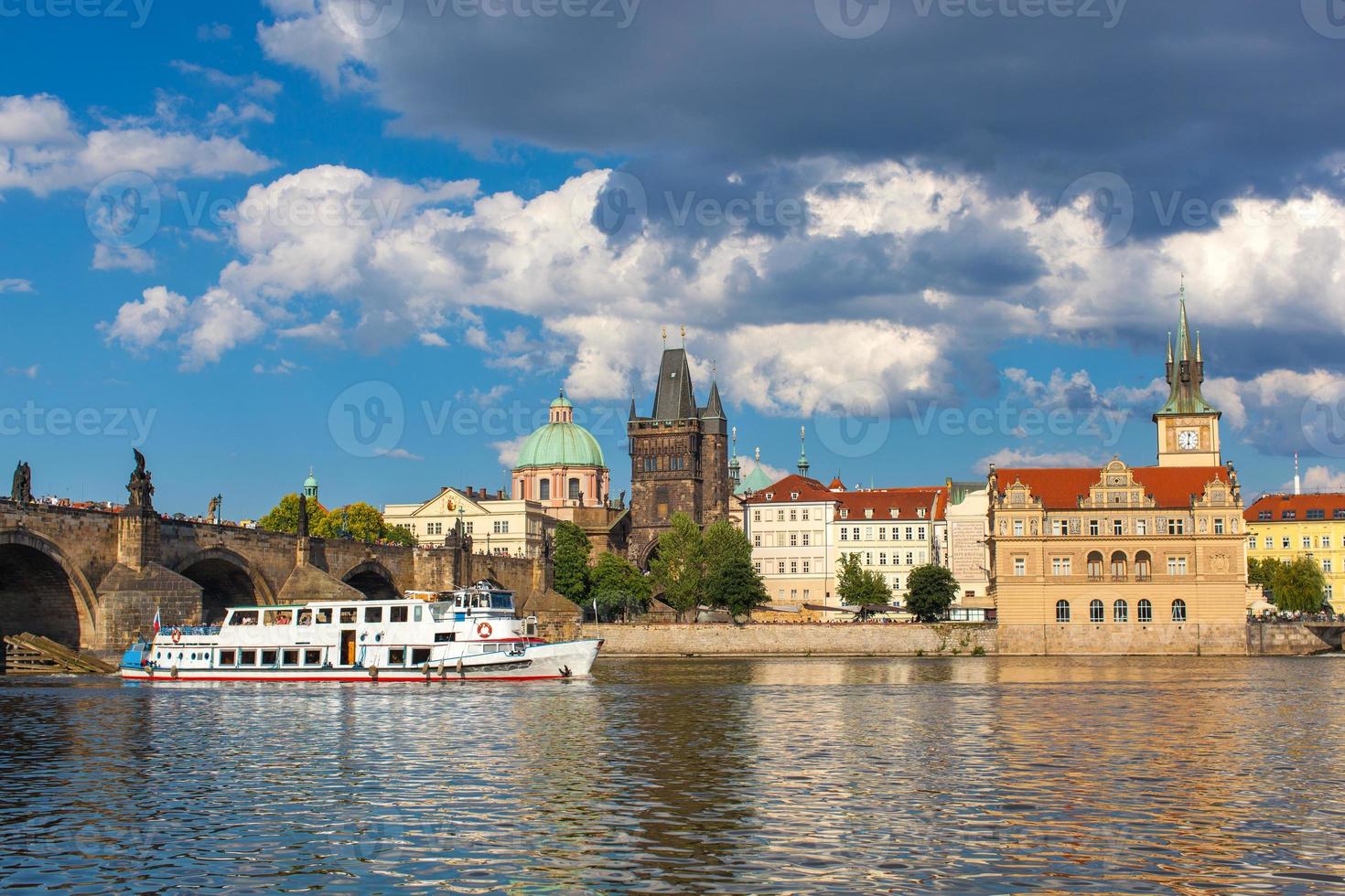 praga, república checa, puente de carlos a través del río vltava en el que navega el barco foto