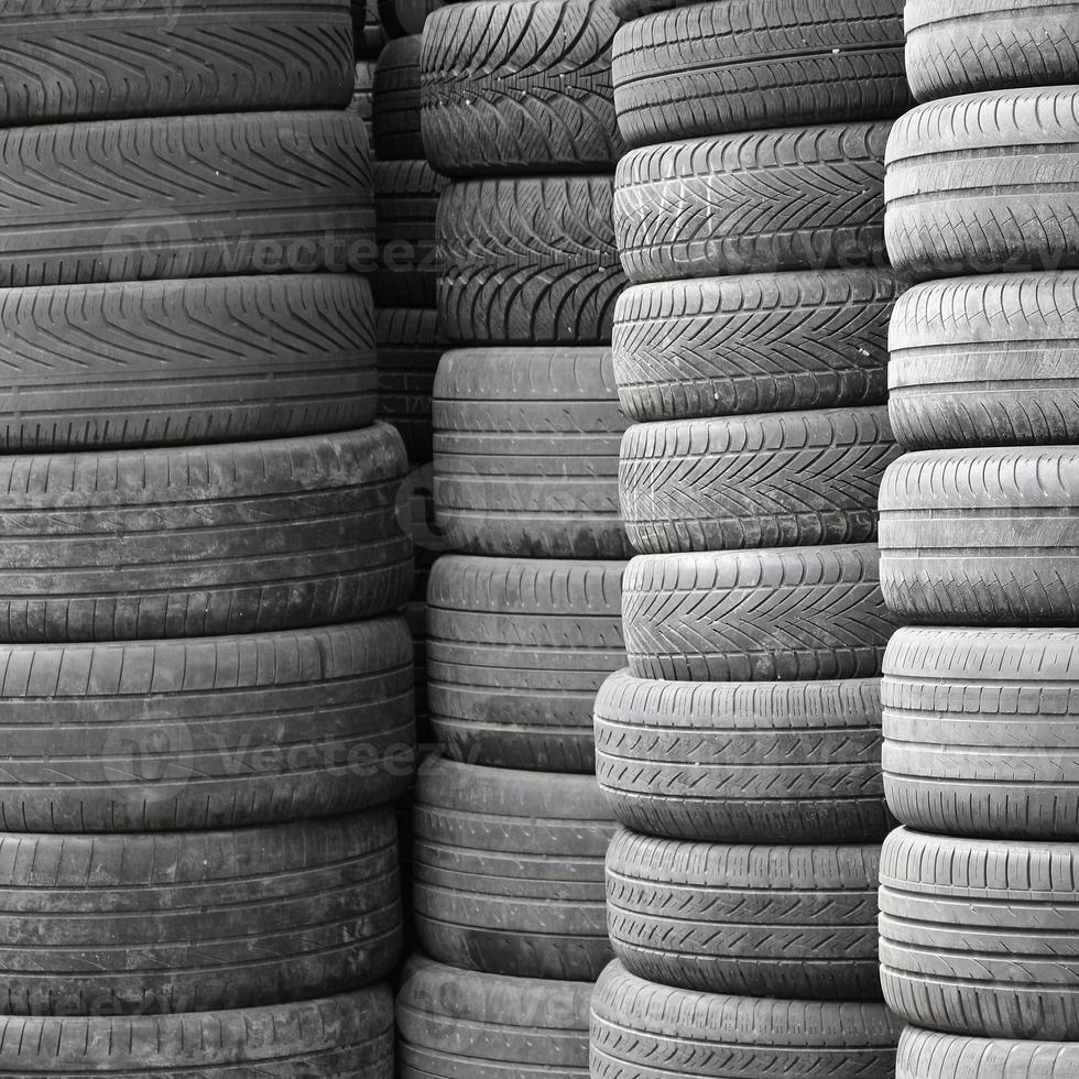 Old used tires stacked with high piles in secondary car parts shop garage photo