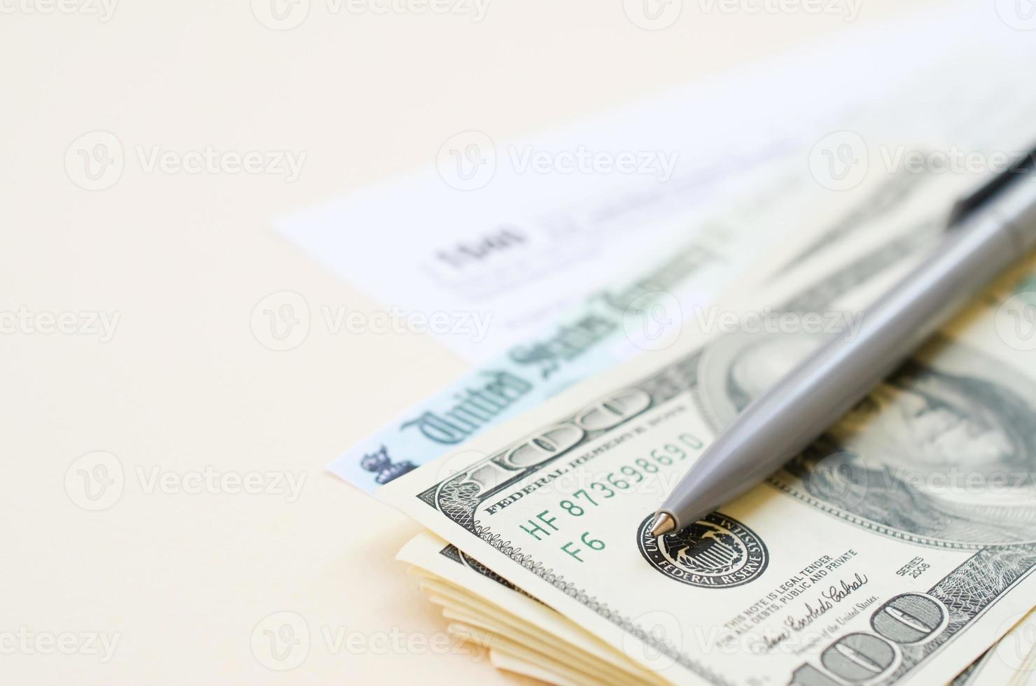 1040 Individual Income tax return form with Refund Check and hundred dollar bills on beige background photo