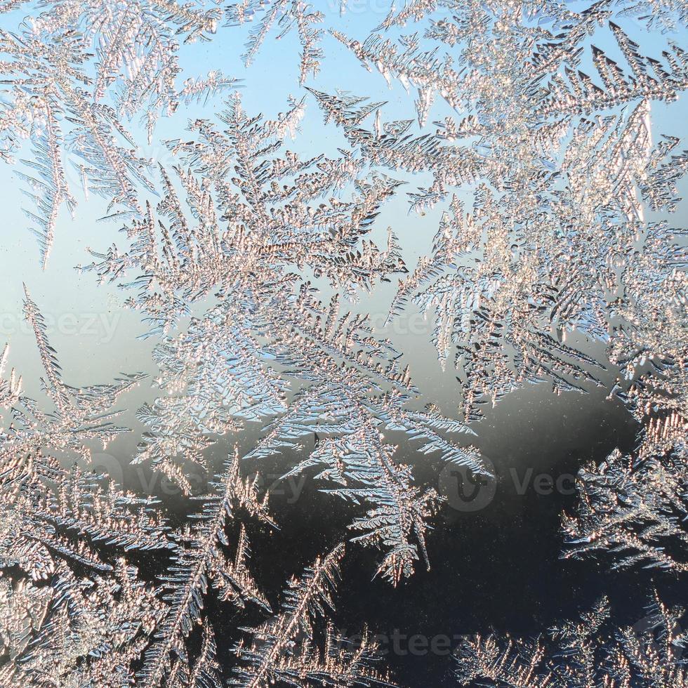 Snowflakes frost rime macro on window glass pane photo