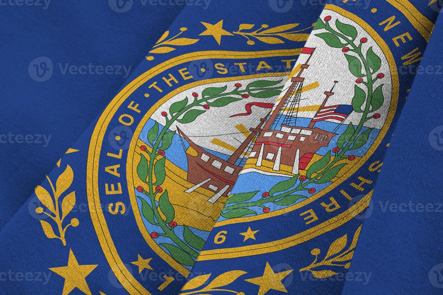 New Hampshire US state flag with big folds waving close up under the studio light indoors. The official symbols and colors in banner photo