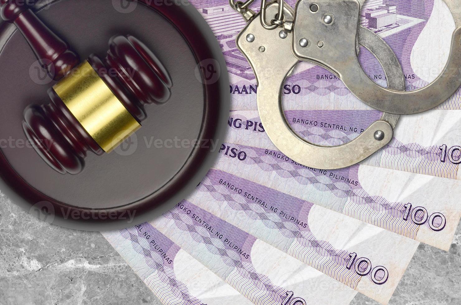 100 Philippine piso bills and judge hammer with police handcuffs on court desk. Concept of judicial trial or bribery. Tax avoidance photo