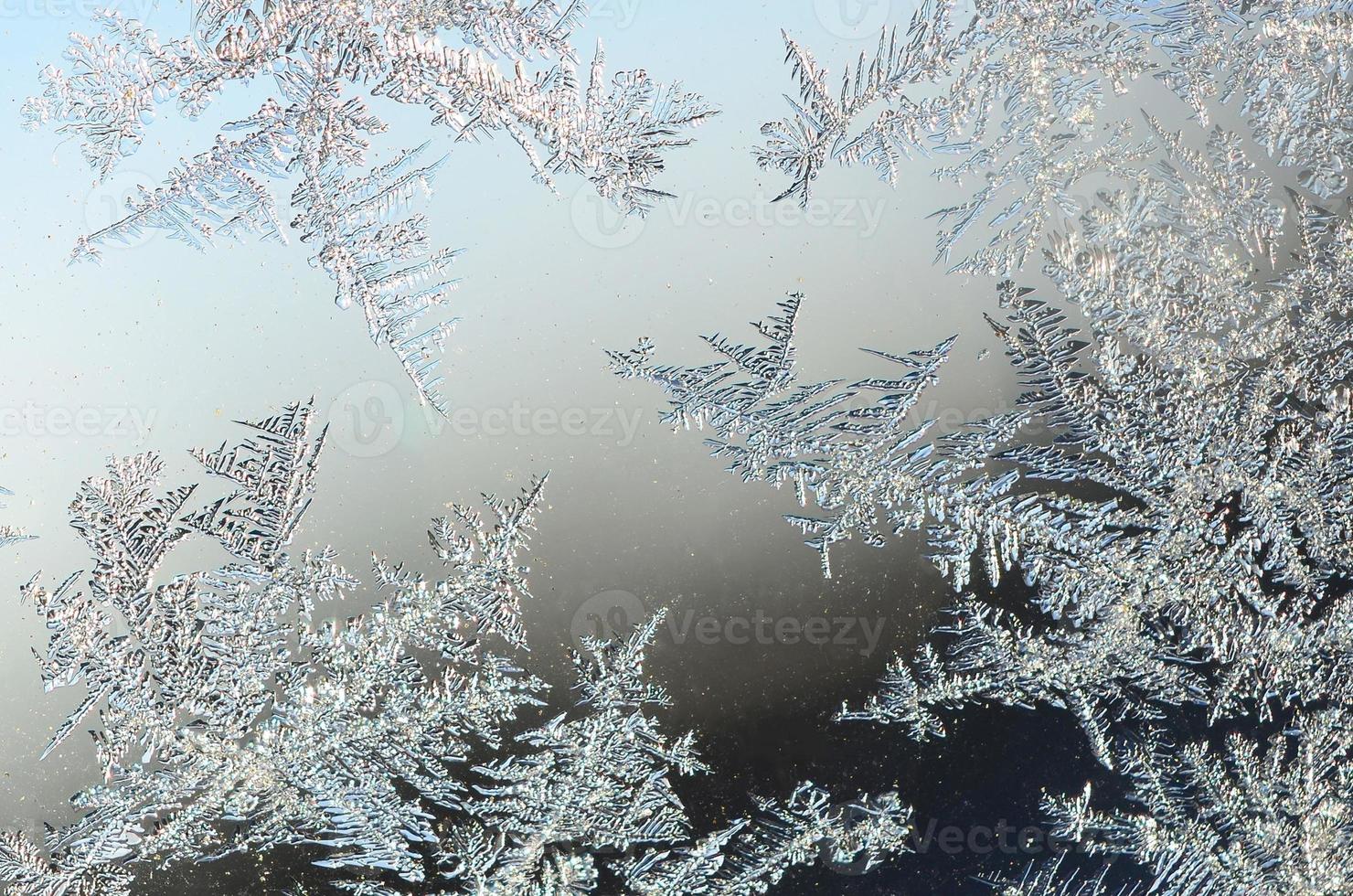 Snowflakes frost rime macro on window glass pane photo