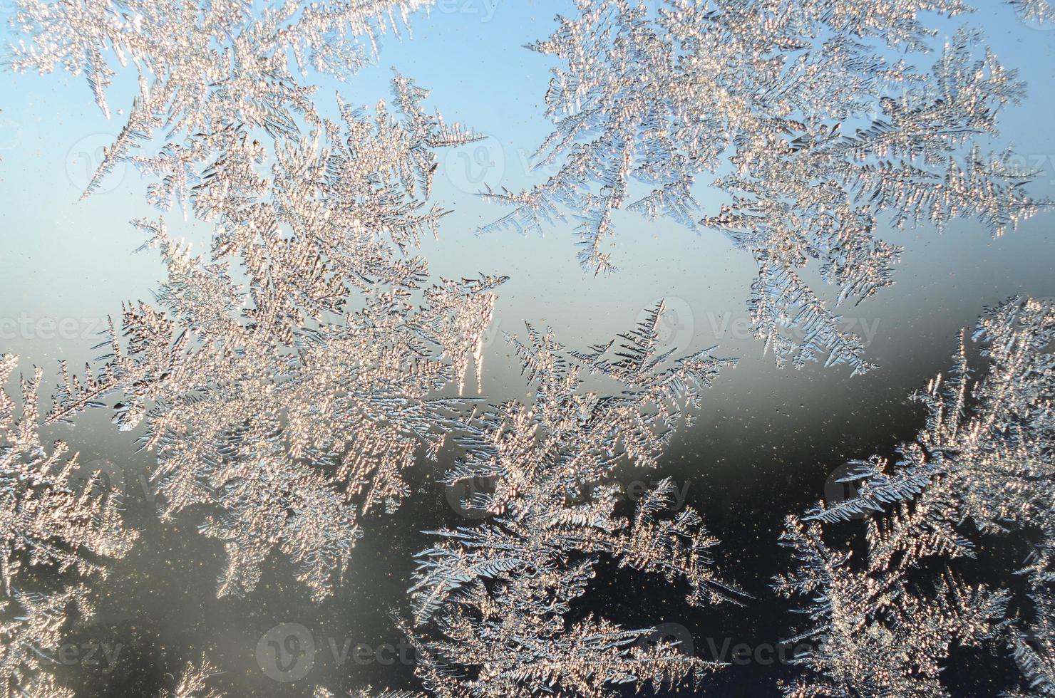 Snowflakes frost rime macro on window glass pane photo