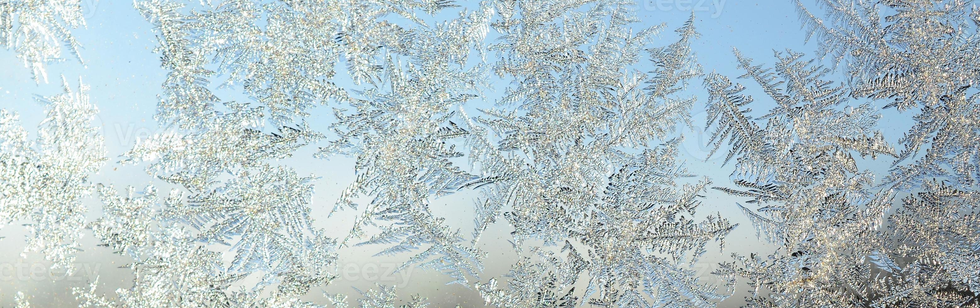 Snowflakes frost rime macro on window glass pane photo