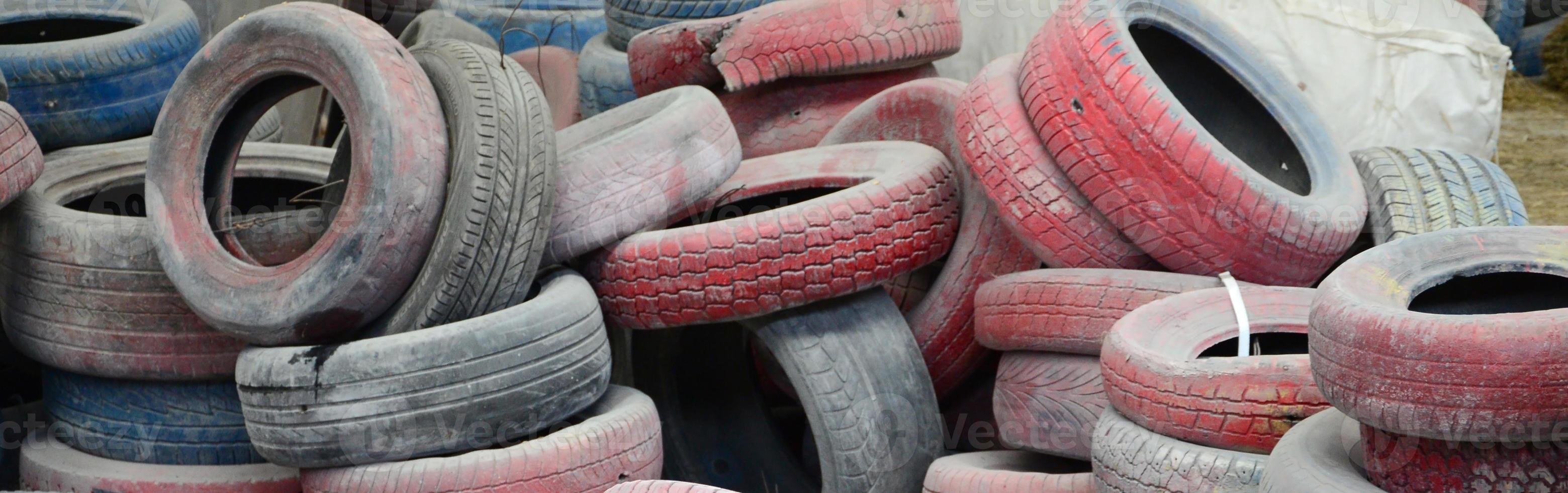 A picture of many old used tires left on a waste dump photo