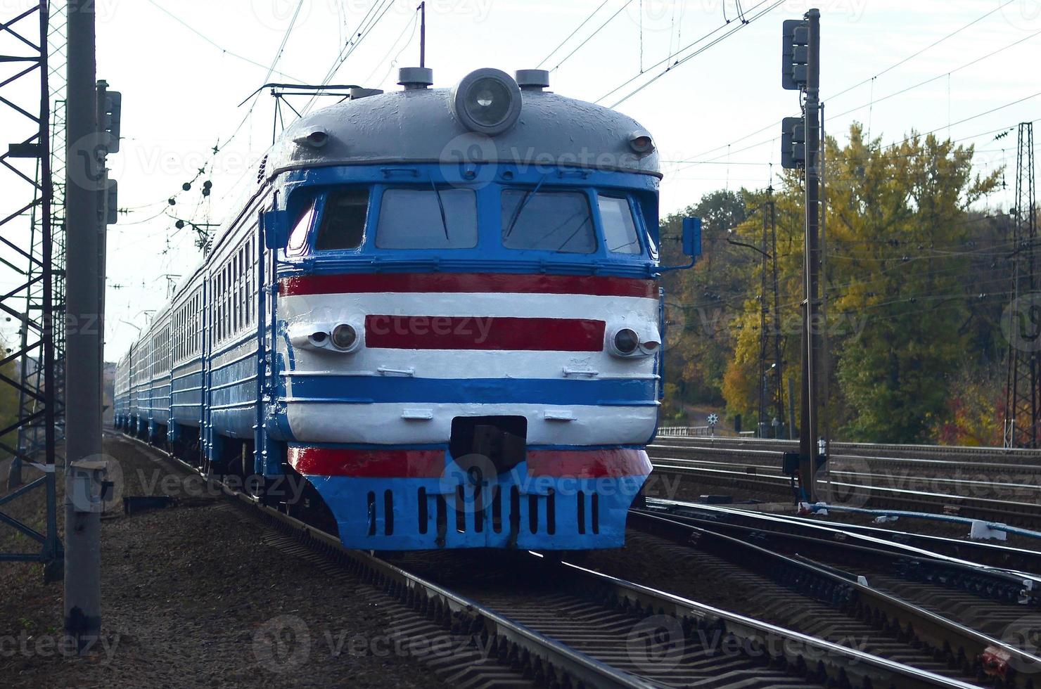 Old soviet electric train with outdated design moving by rail photo