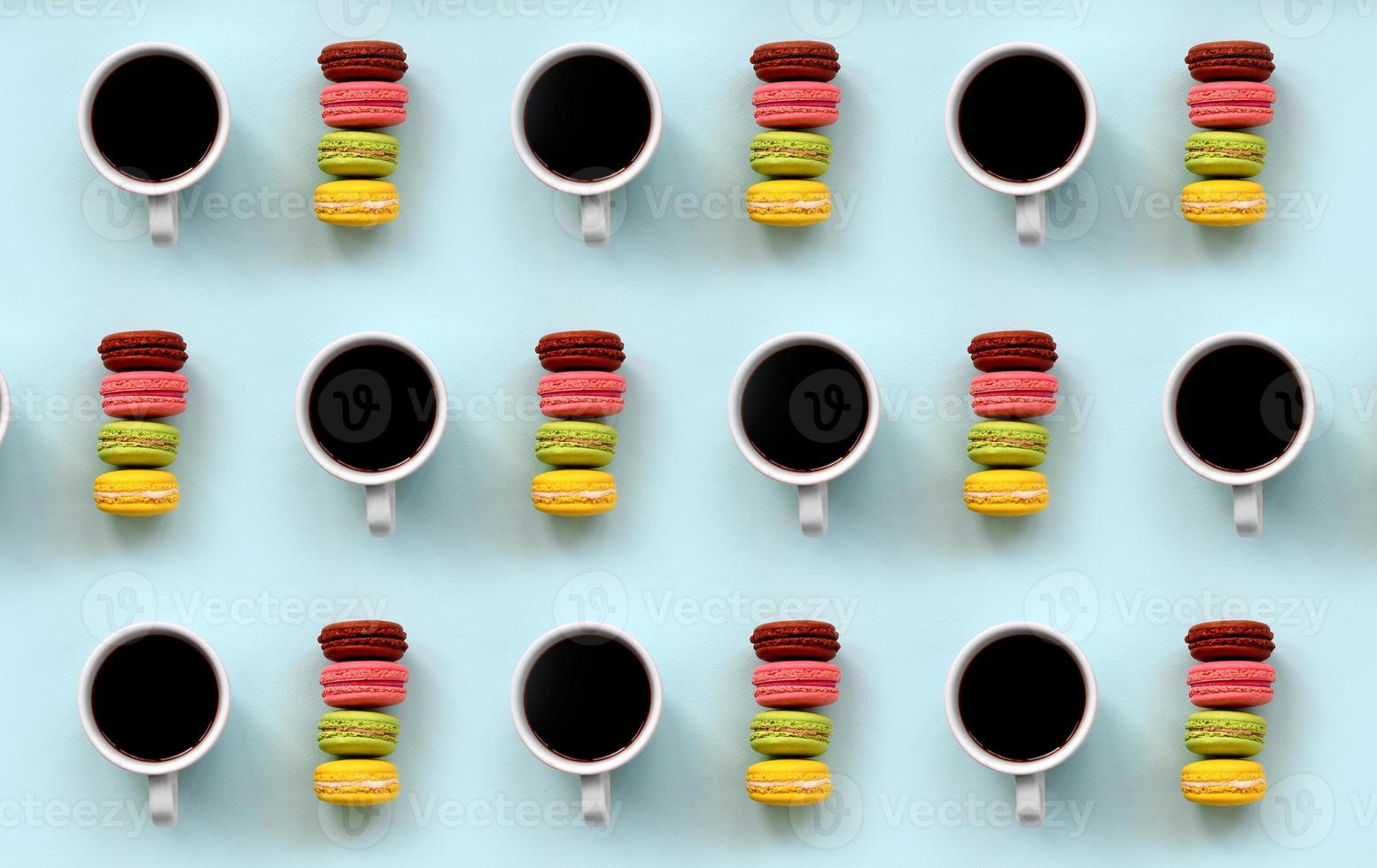 A pattern of many colorful dessert cake macaroon and coffee cups on trendy pastel blue background top view. Flat lay composition photo