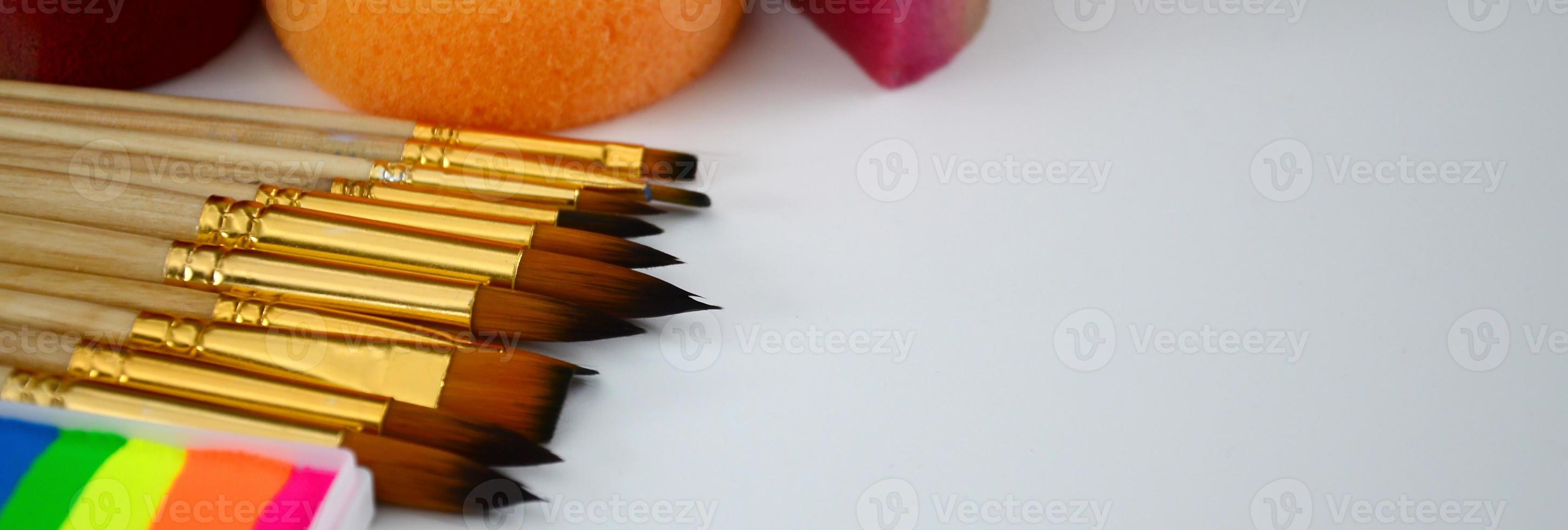 Color cosmetics, brushes and sponges for face painting on white background photo