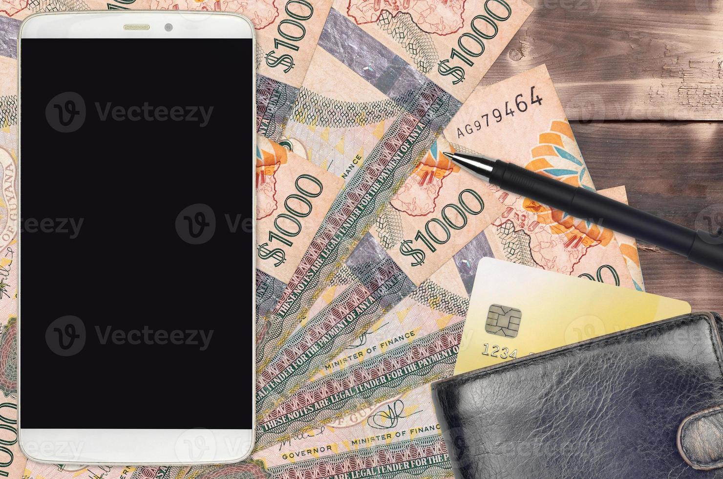 1000 Guyanese dollars bills and smartphone with purse and credit card. E-payments or e-commerce concept. Online shopping and business with portable devices photo