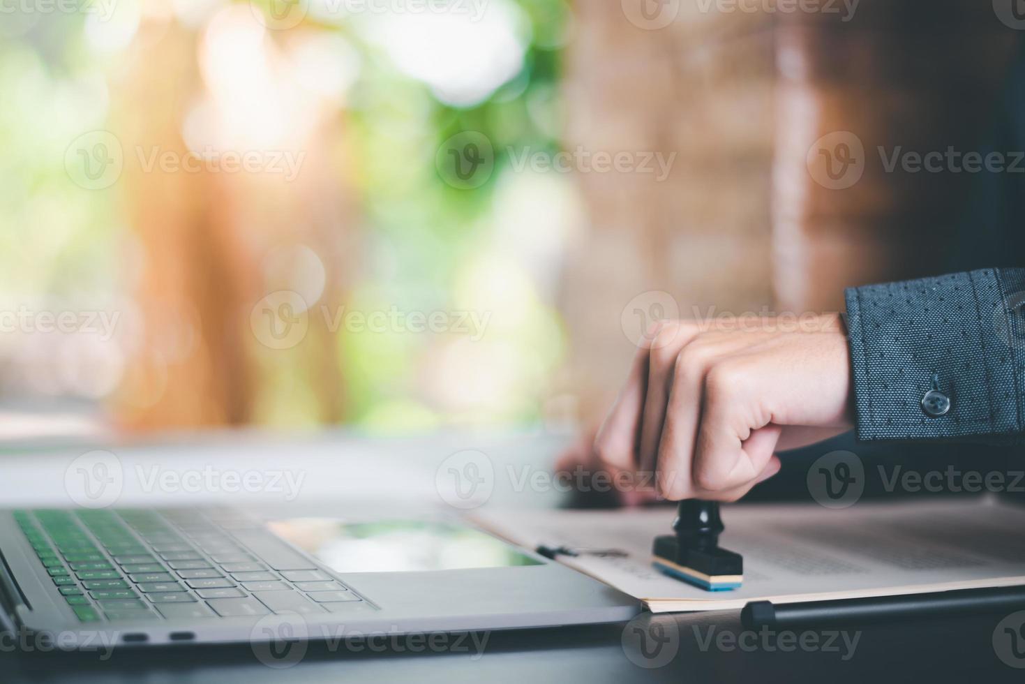 Businessman validates and manages business documents and agreements, signing a business contract approval of contract documents confirmation or warranty certificate,approval stamp photo