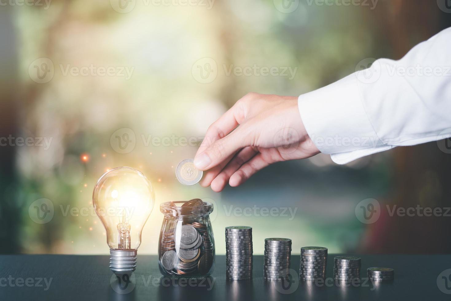 Businessman putting coins into glass jar , finance and banking, fund growth and savings concept, proportional money management to spend effectively,Planning for savings for the future photo