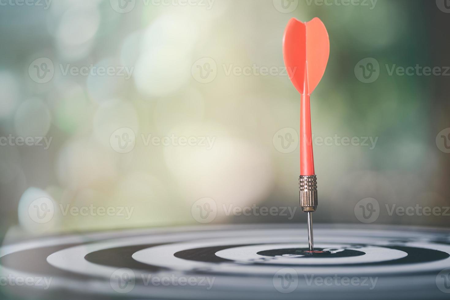 flecha de dardo golpeando en el centro de destino del tablero de dardos, orientación comercial y concepto de enfoque, crecimiento y propósito de la organización, gestión de planificación de estrategia de marketing competitivo foto