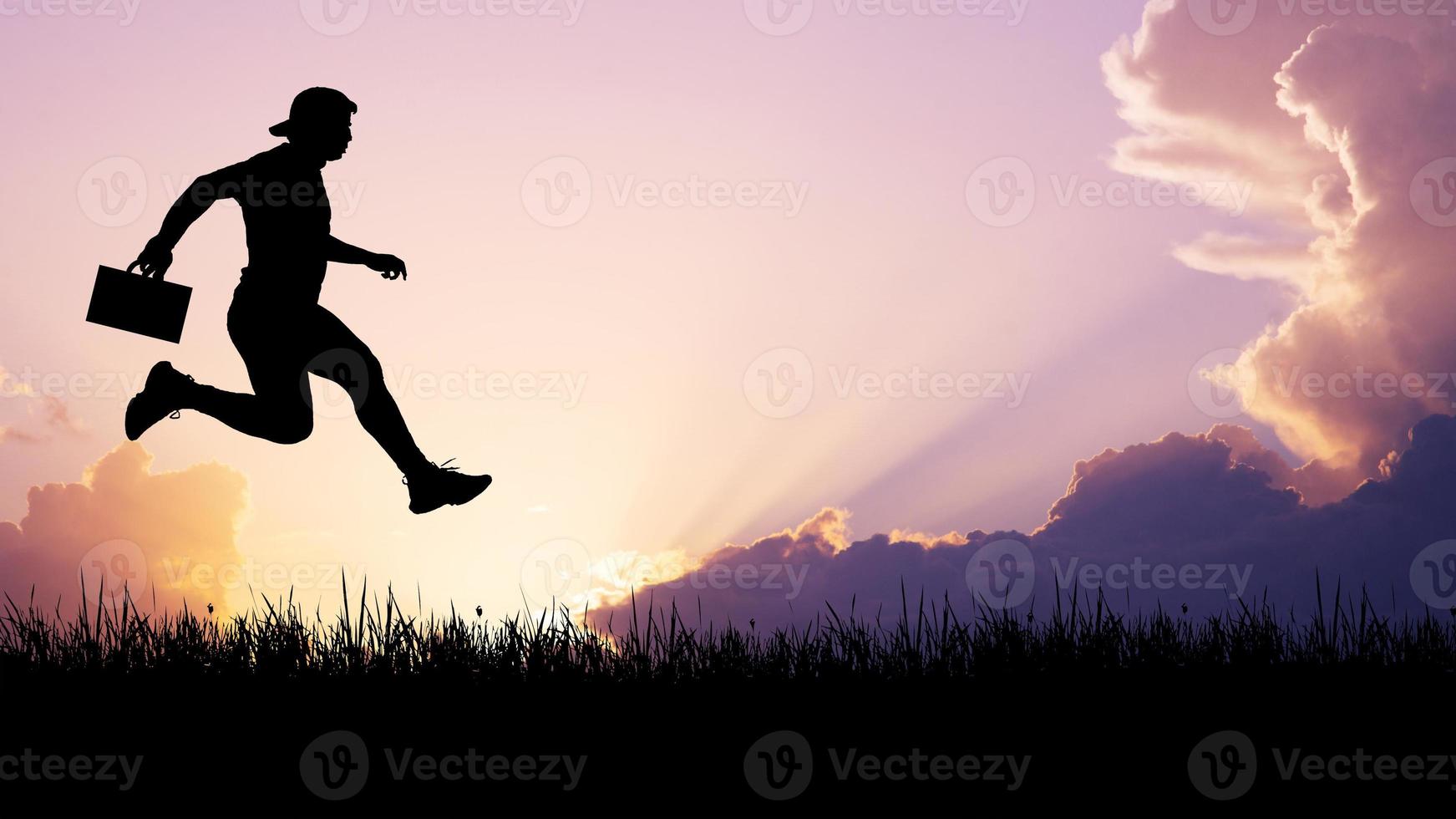 Silhouette of a man jumping in the meadow. The business man concept moves forward in the future. photo