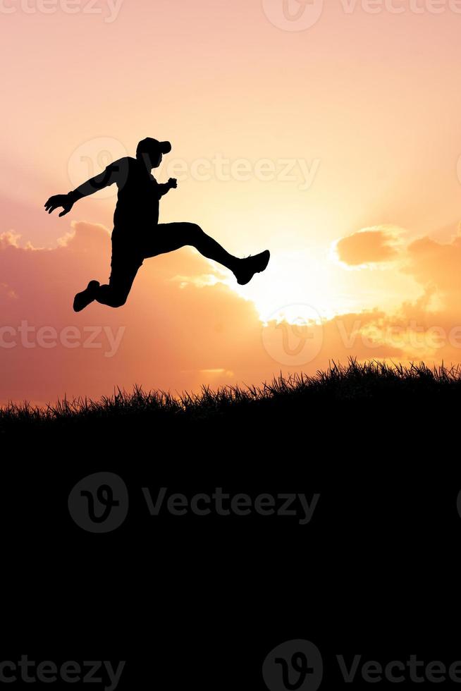 Vertical silhouette of a man jumping to the future. The concept of moving on to something better photo