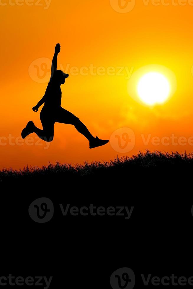 Vertical silhouette of a man jumping to the future. The concept of moving on to something better photo