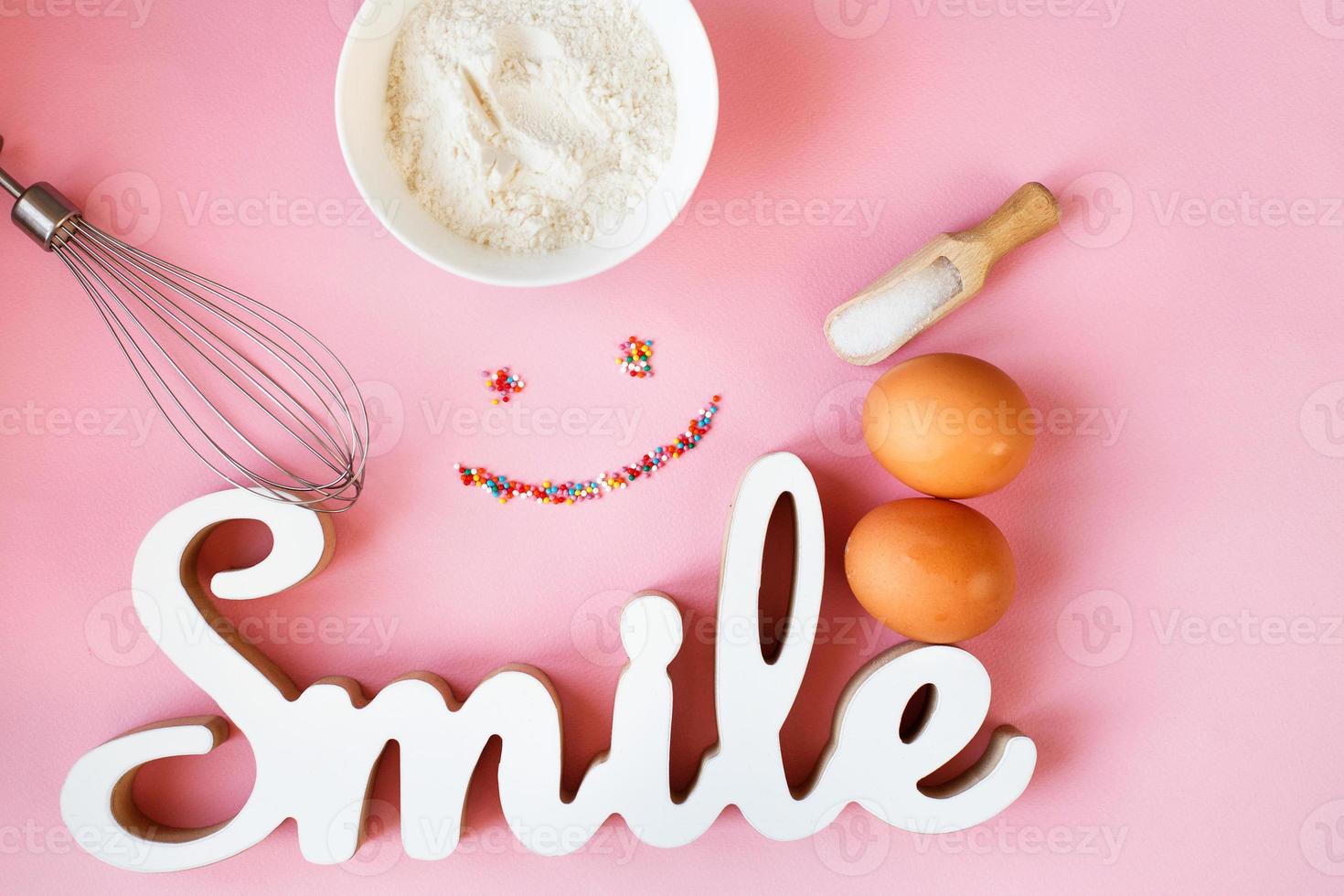 Ingredients for cooking baking - flour, egg, sugar, rolling pin on pink background. Concept of cooking dessert photo