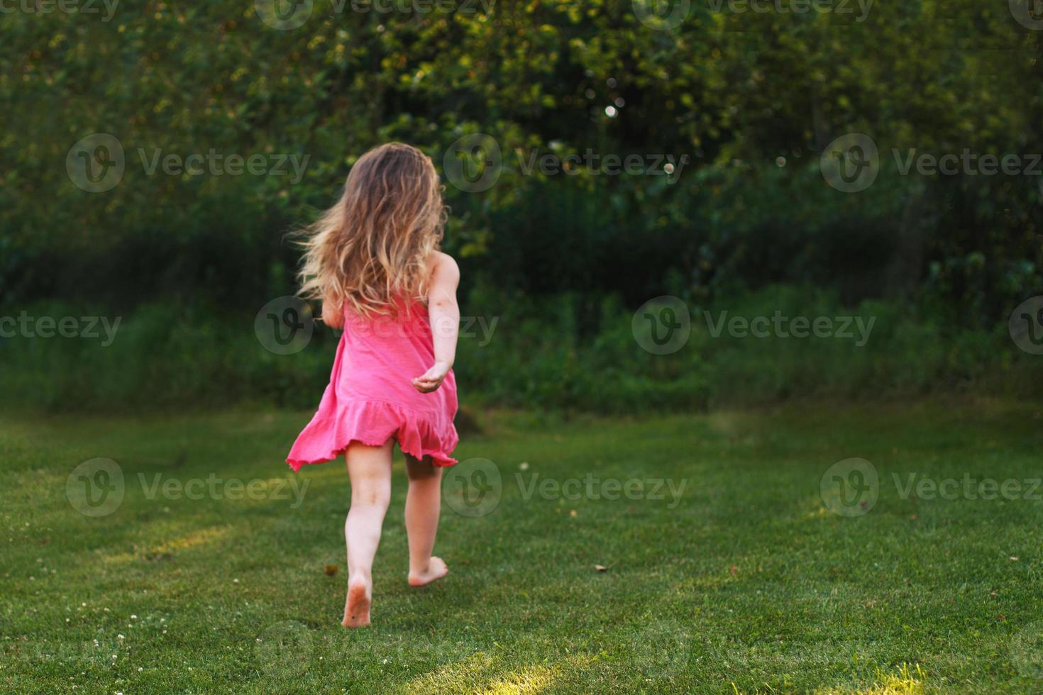 happy baby smiling. little girl running at a sunset outdoor photo