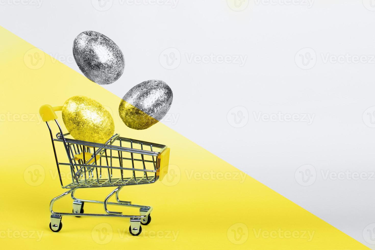Easter golden and silver eggs levitation to shopping cart on Illuminating and Ultimate Grey background. Easter concept. photo