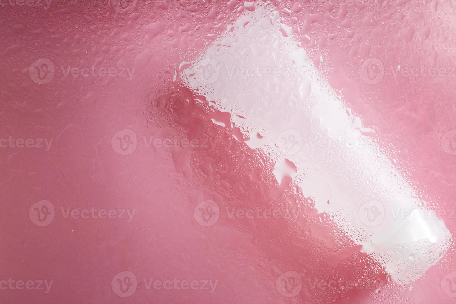 moisturizing skin care products. Face and hand cream under a glass surface with water on a pink background. spa cosmetic photo