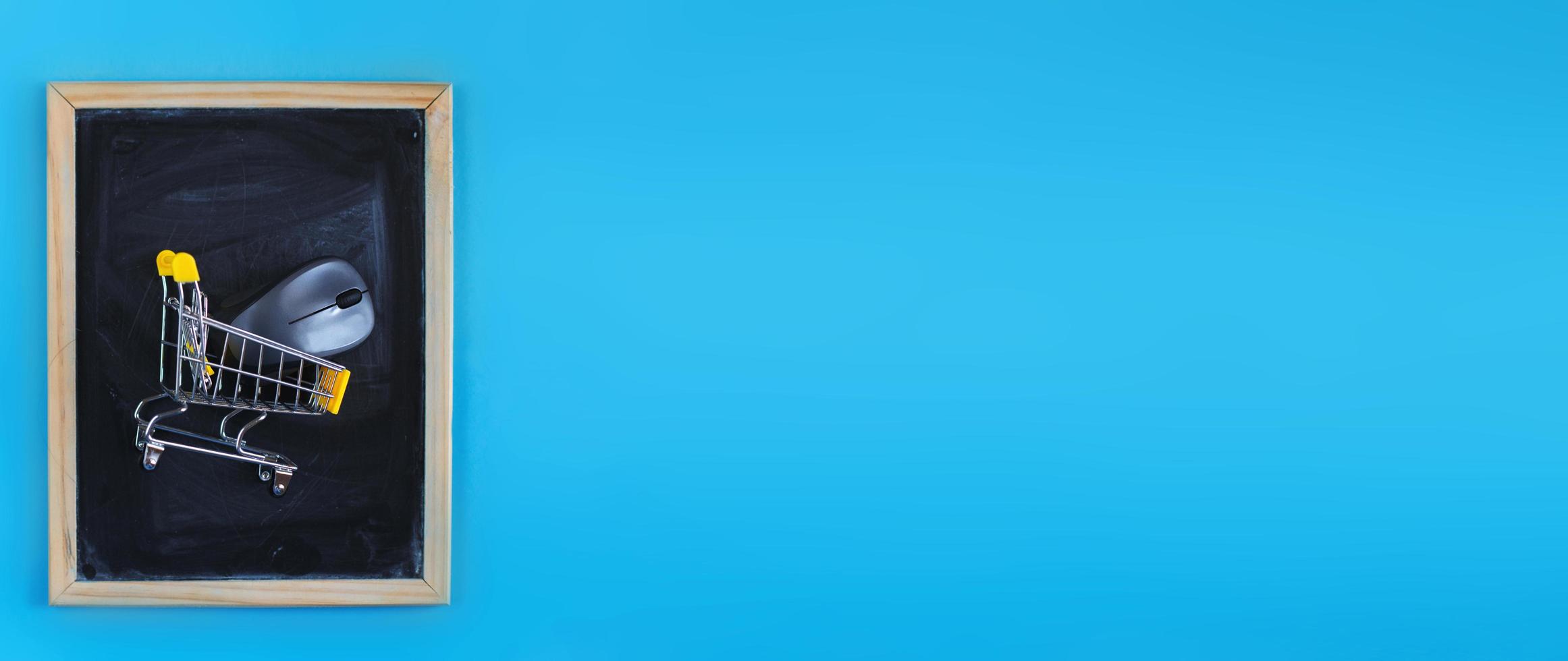 School chalkboard with a shopping cart and computer mouse on blue background. Back to school concept. banner photo