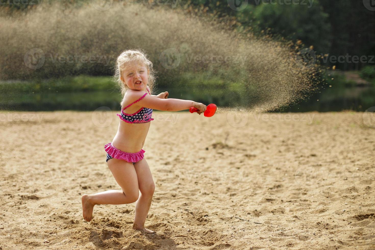 Girl throws sand. Beautiful girl playing with sand on beach. child having fun. vacation happiness and freedom concept. photo