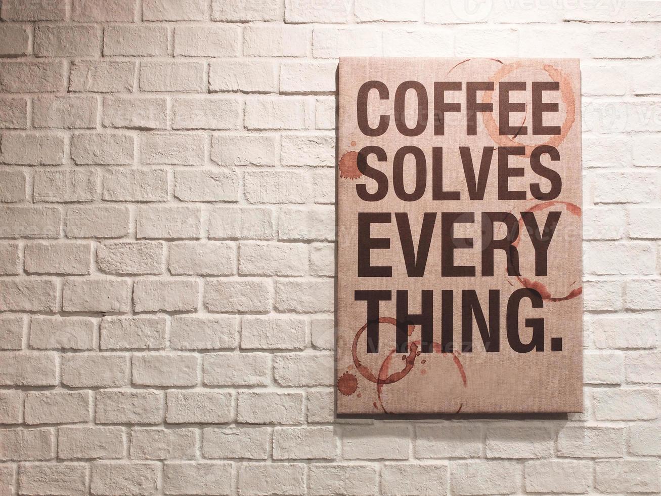 cita inspiradora y motivadora sobre el café en un marco de lienzo colgado en una pared de ladrillos en el café foto