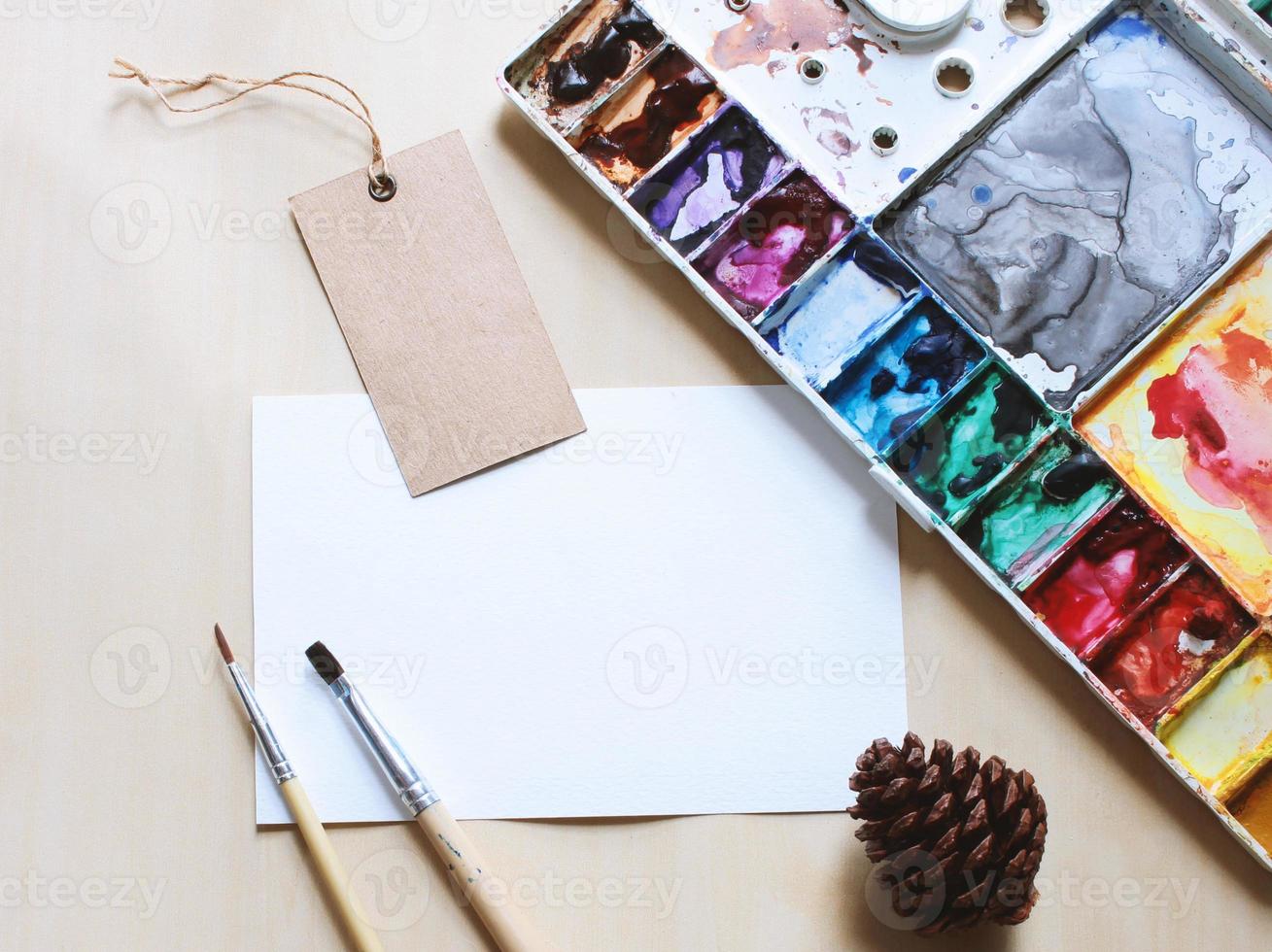 Artist workspace mock up with brush and paint on blank card photo