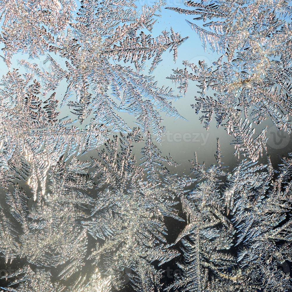 Snowflakes frost rime macro on window glass pane photo