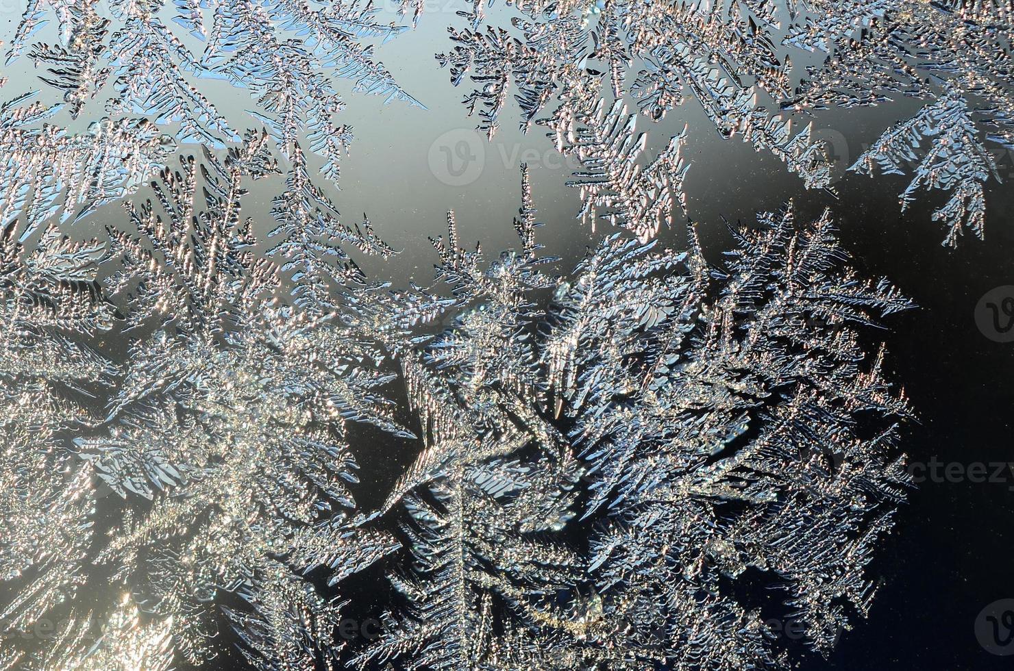 Snowflakes frost rime macro on window glass pane photo