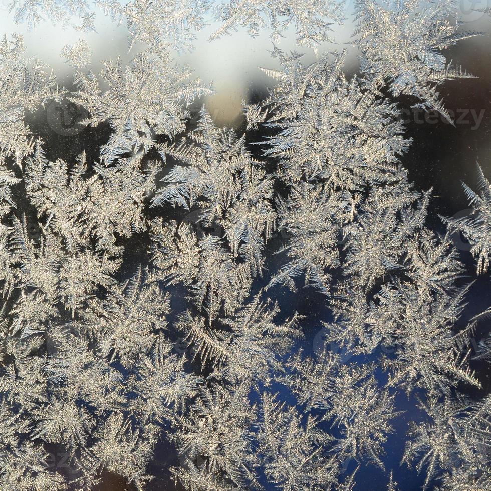 Snowflakes frost rime macro on window glass pane photo