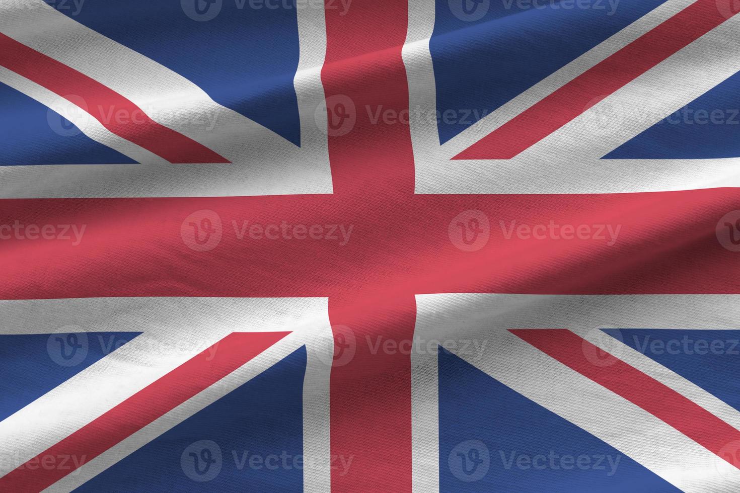 Great britain flag with big folds waving close up under the studio light indoors. The official symbols and colors in banner photo