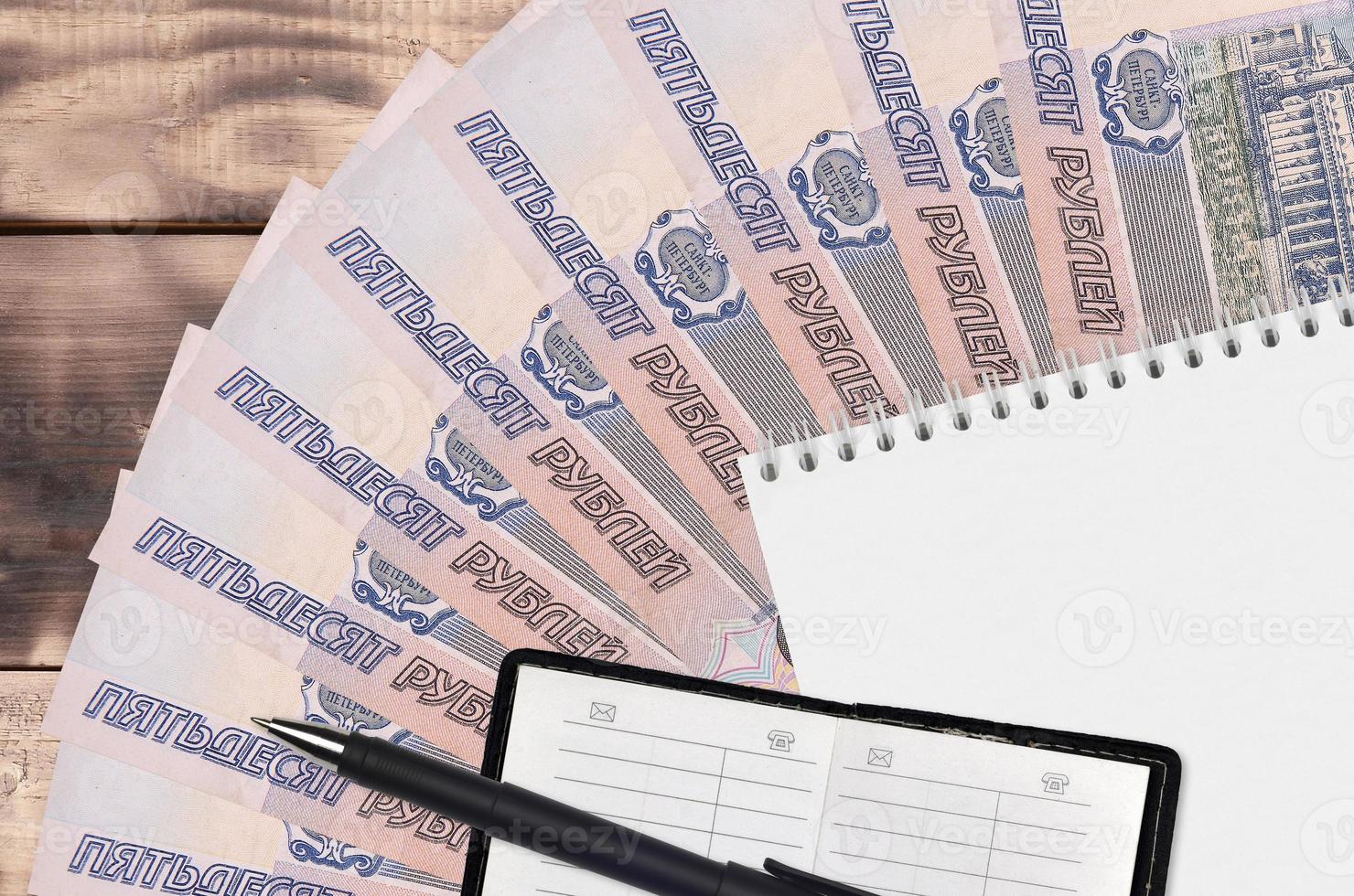 50 russian rubles bills fan and notepad with contact book and black pen. Concept of financial planning and business strategy photo