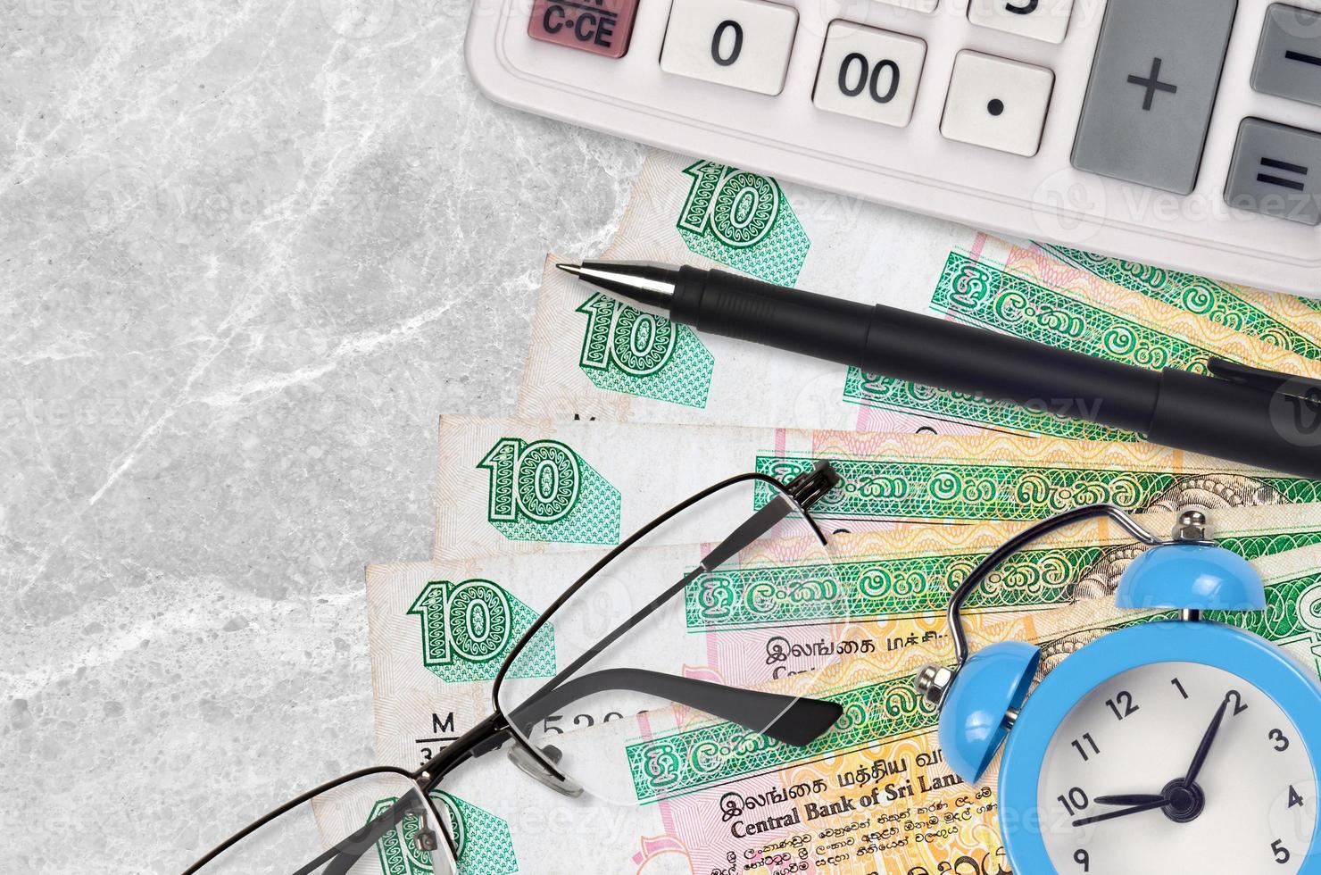 10 Sri Lankan rupees bills and calculator with glasses and pen. Business loan or tax payment season concept. Time to pay taxes photo