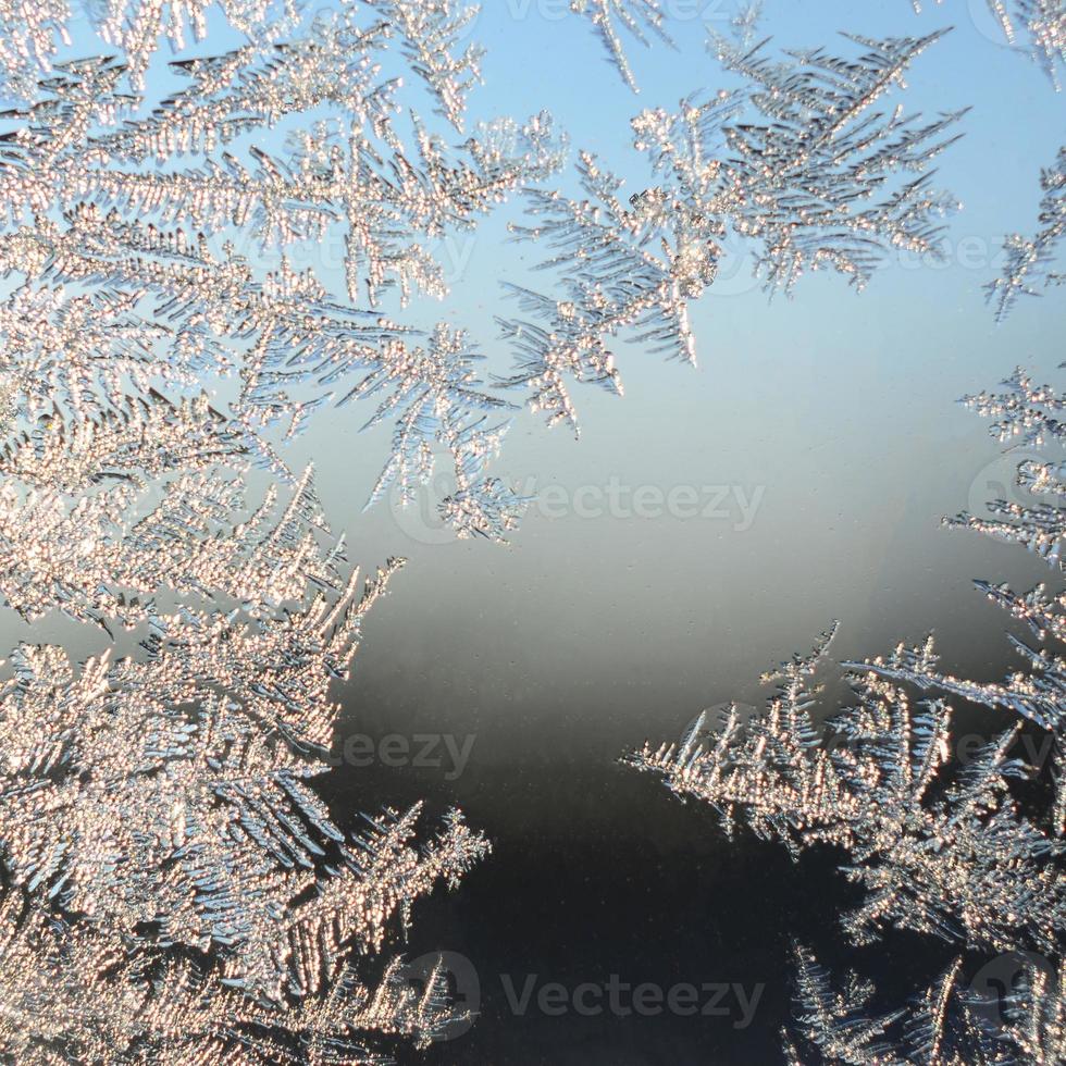 Snowflakes frost rime macro on window glass pane photo