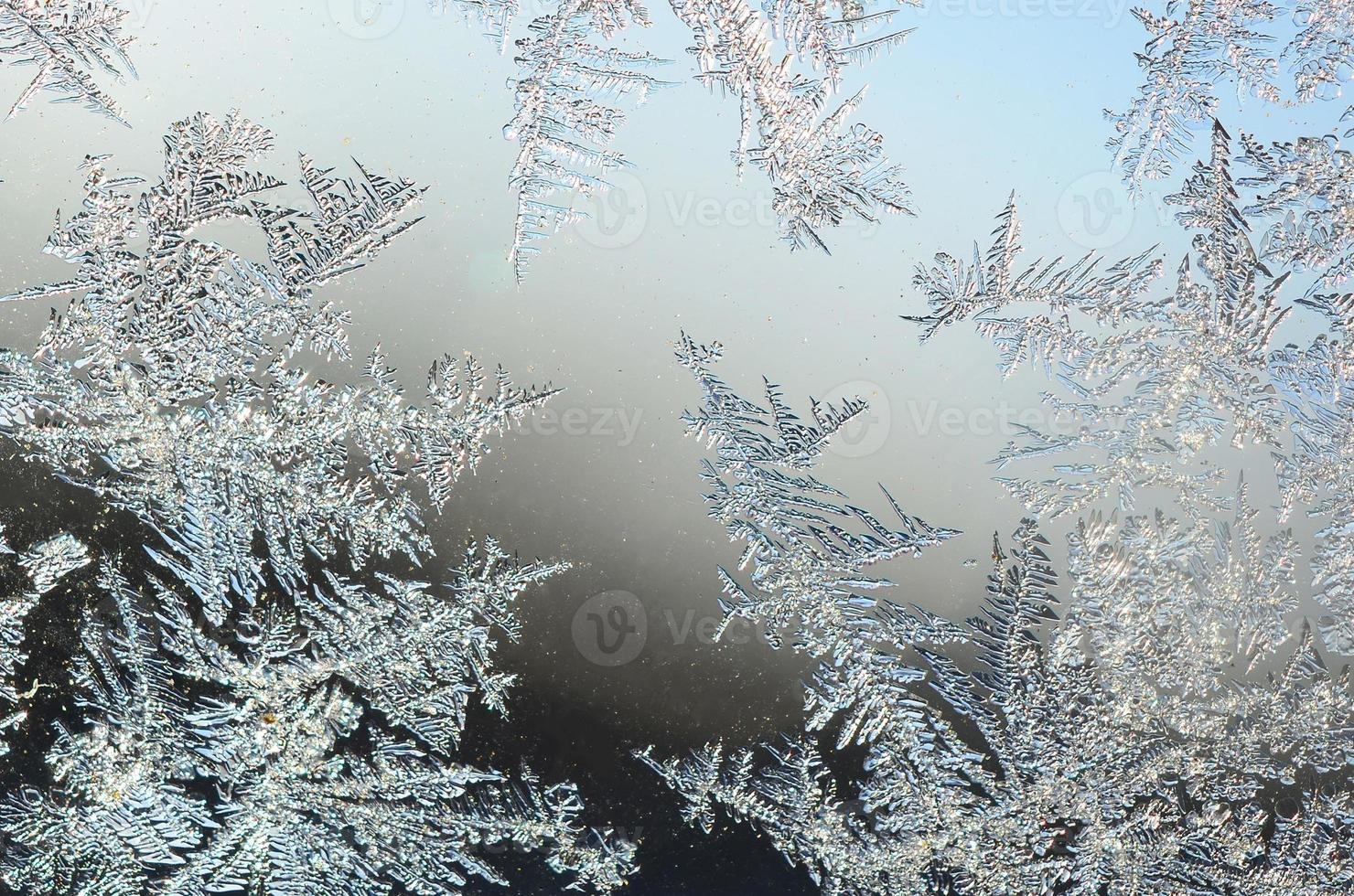 Snowflakes frost rime macro on window glass pane photo