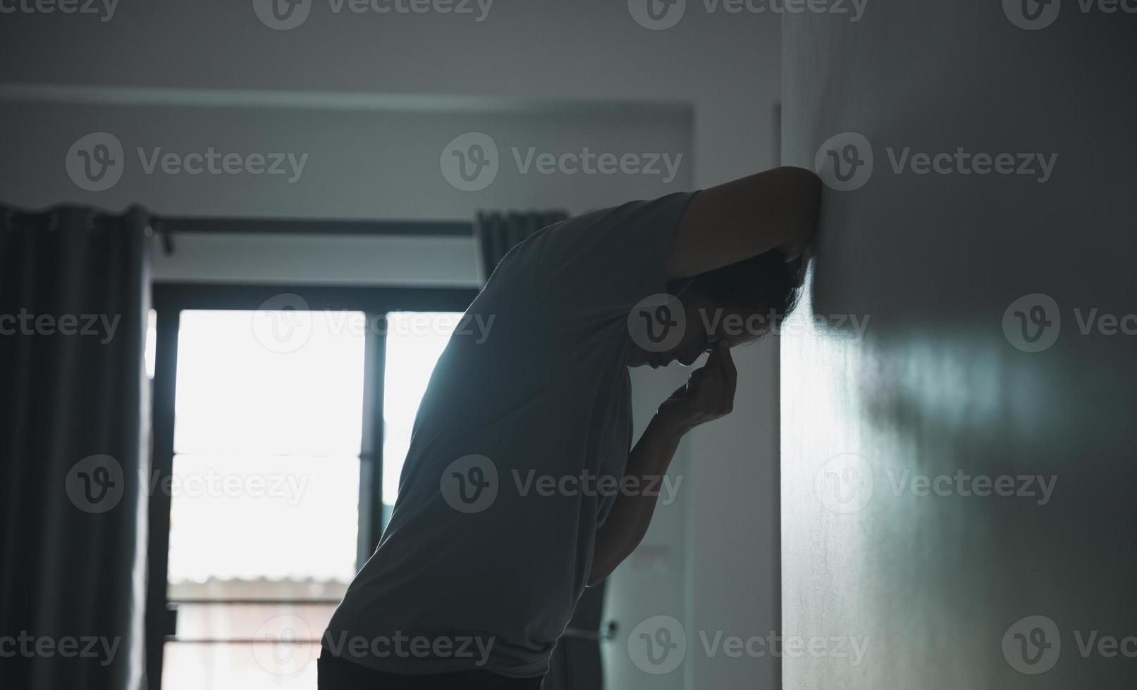 Schizophrenia with lonely and sad in mental health depression concept. Depressed woman standing against with dark room feeling miserable at home . Women are depressed, fearful and unhappy. photo