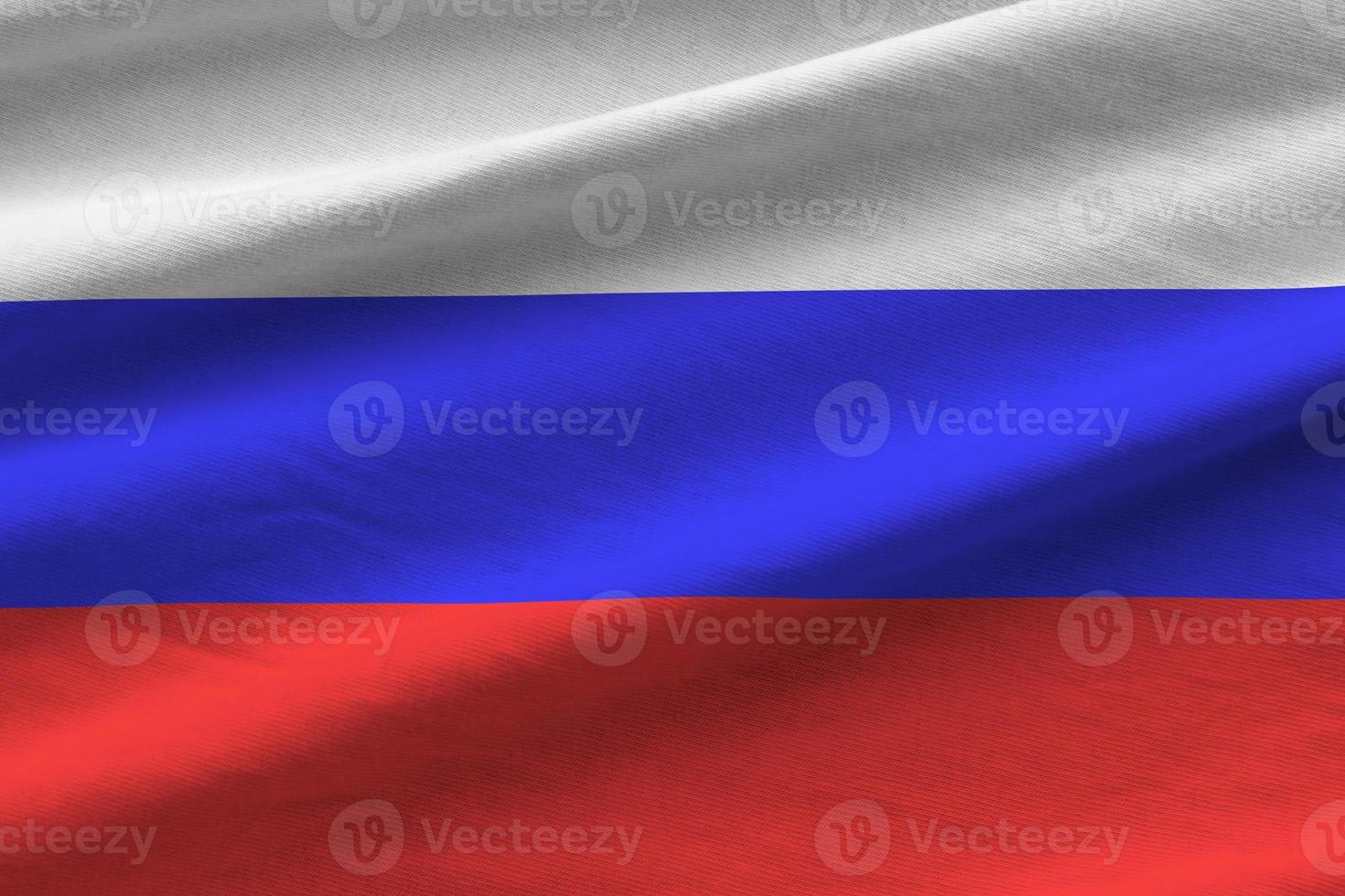 Russia flag with big folds waving close up under the studio light indoors. The official symbols and colors in banner photo